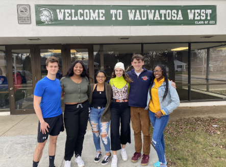 Walkout organizers pose in front of the Wauwatosa West sign. 