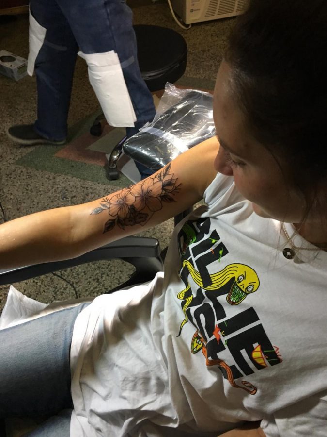 West Senior Isabella Jacobson receives a tattoo on her arm at a tattoo parlor. 