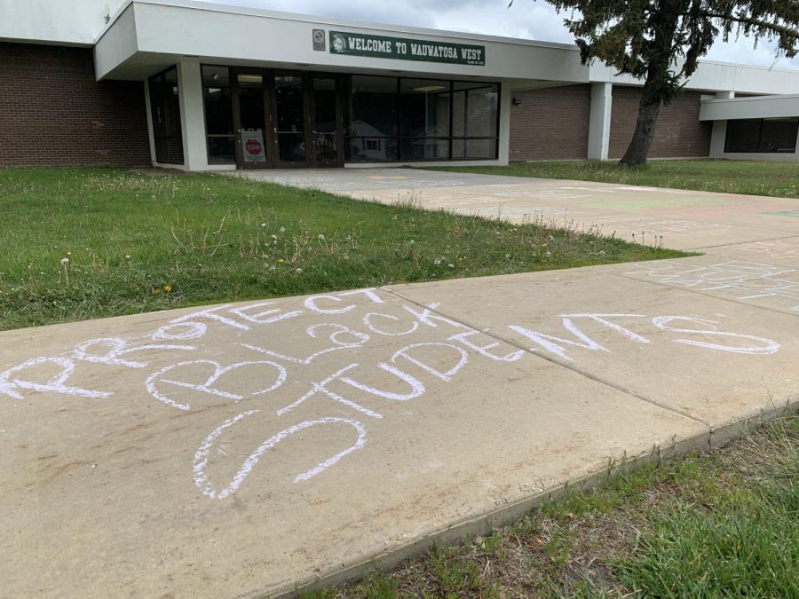“Protect Black Students” and other messages appear written in chalk on the sidewalk along Center Street outside Wauwatosa West on Sat. May 15, 2021, after a group of protesters met Friday evening, May 14, 2021, in response to videos that have been circulating among West students.