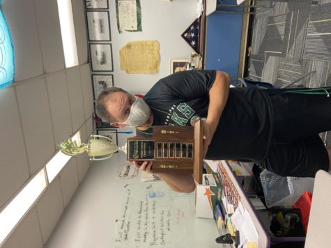 Mr. Mateske poses with the homecoming trophy that has been proudly displayed in his room for the last three years in  a row. 