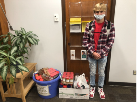 Evan standing with the peanut butter that was collected for the Tosa Cares Pantry. “It was more than I expected.” he said. 
