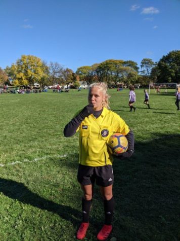 Annabelle Wooster, student referee, stands on the field while working a recreational game at Nash Park in Milwaukee.