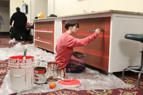 Waier paints the counter that will soon be used to sell flowers and snacks. 