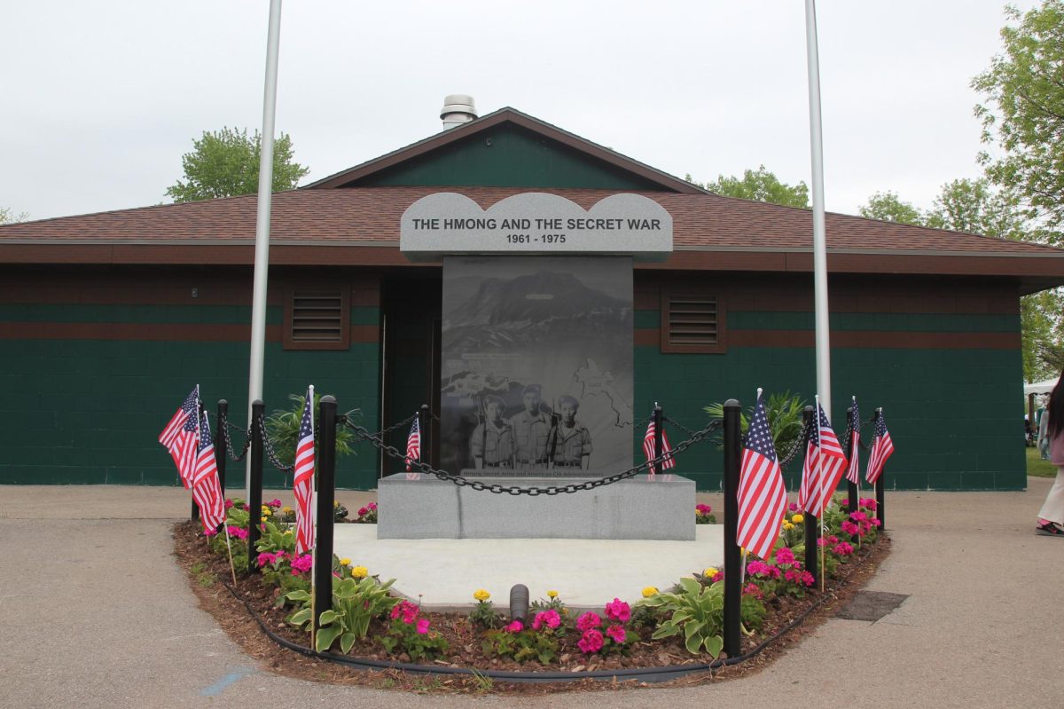 A memorial honoring Hmong veterans of the Secret War of Laos stands at the entrance of the tournament, establishing the historical sacrifices that serve as the foundation for cultural preservation today. 
