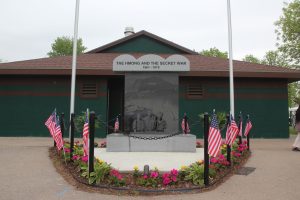 A memorial honoring Hmong veterans of the Secret War of Laos stands at the entrance of the tournament, establishing the historical sacrifices that serve as the foundation for cultural preservation today. 
